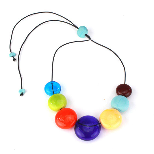 A vibrant necklace featuring seven hollow, hand-blown glass beads in bright multi-colors, strung on adjustable leather for versatile styling options.