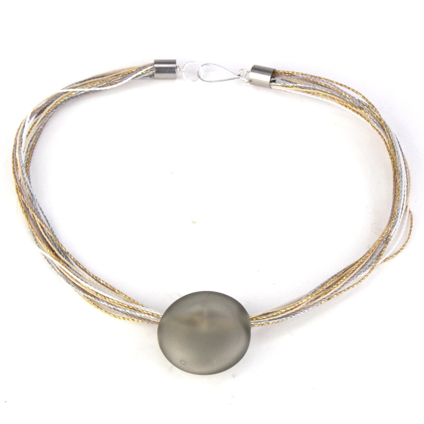 A sophisticated necklace featuring a hand-blown frosted grey glass focal bead strung on multi-strand waxed cord in neutral tones of grey, cream, and beige. Finished with a sterling silver hook-and-loop clasp, this piece offers timeless elegance for any occasion.