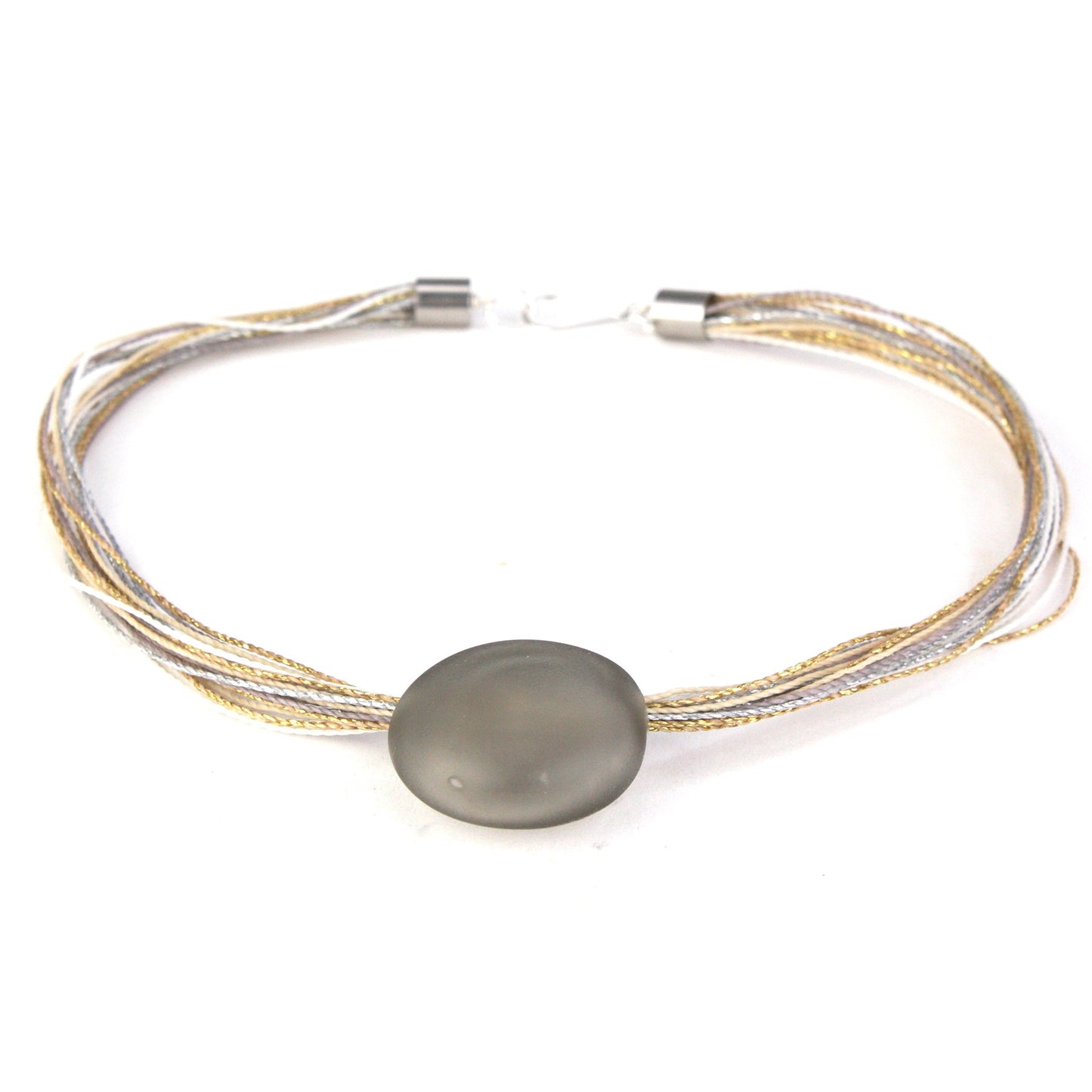 A sophisticated necklace featuring a hand-blown frosted grey glass focal bead strung on multi-strand waxed cord in neutral tones of grey, cream, and beige. Finished with a sterling silver hook-and-loop clasp, this piece offers timeless elegance for any occasion.