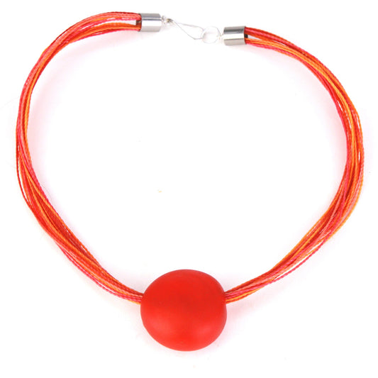 A vibrant necklace featuring a hand-blown orange glass focal bead strung on multi-strand waxed cord in warm orange and tangerine tones. Finished with a sterling silver hook-and-loop clasp, this piece adds a bold and colorful touch to any outfit.