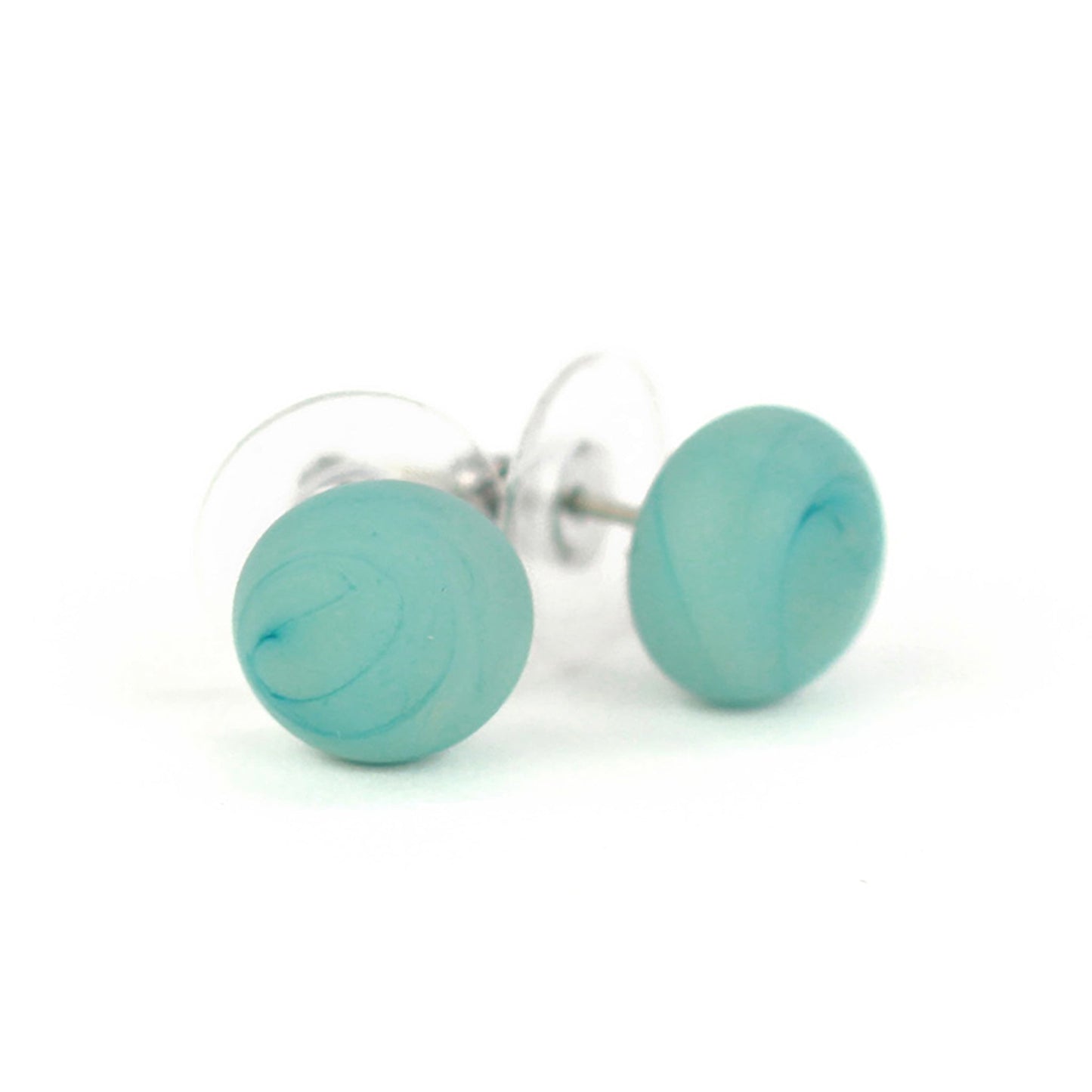 Pair of small turquoise swirled glass stud earrings with matte finish and sterling silver posts, paired with clear earring backs.