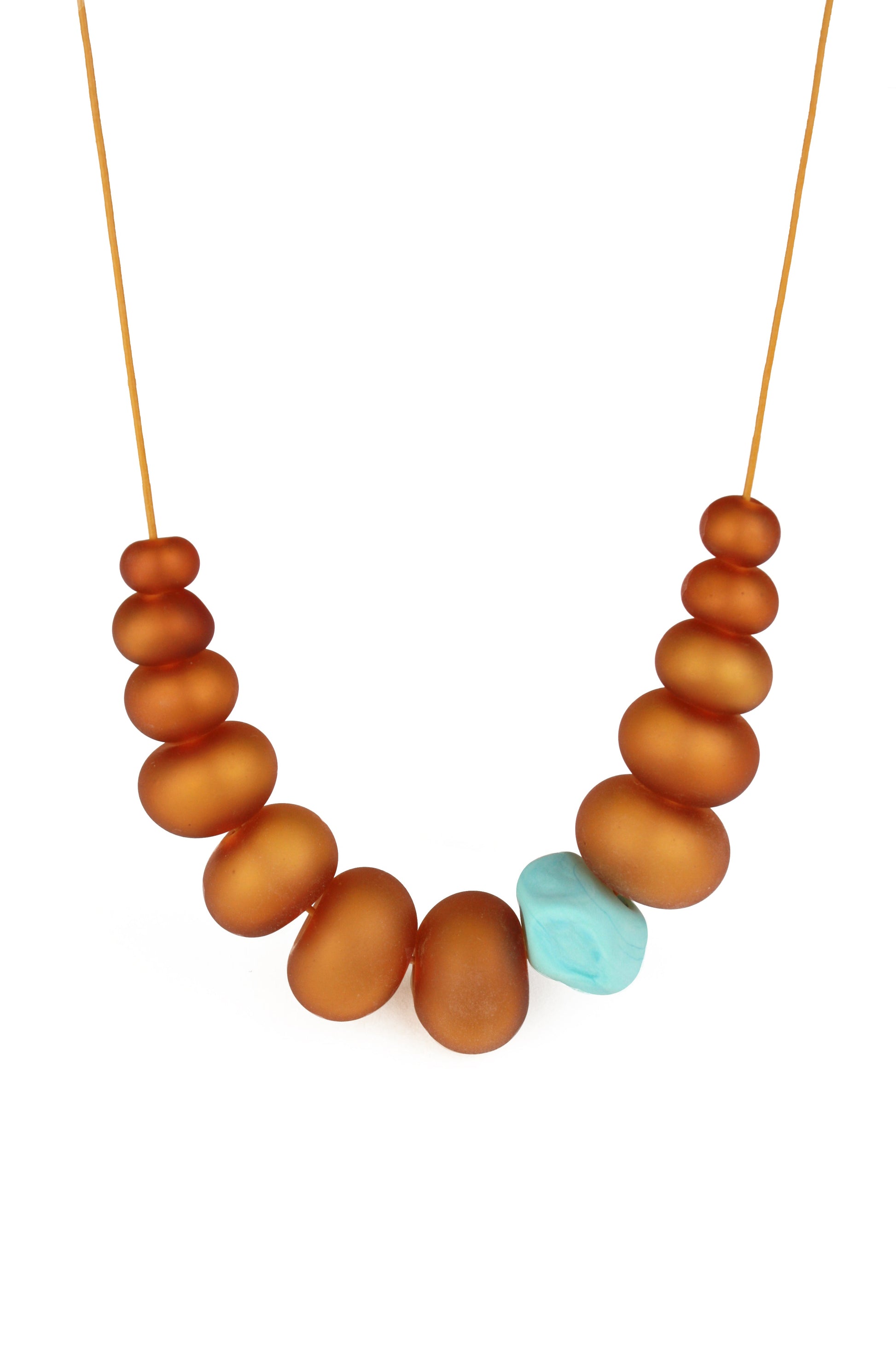 Necklace of hand blown and sandblasted hollow beads in velvety shades of amber glass paired with a turquoise glass nugget bead and strung on adjustable leather