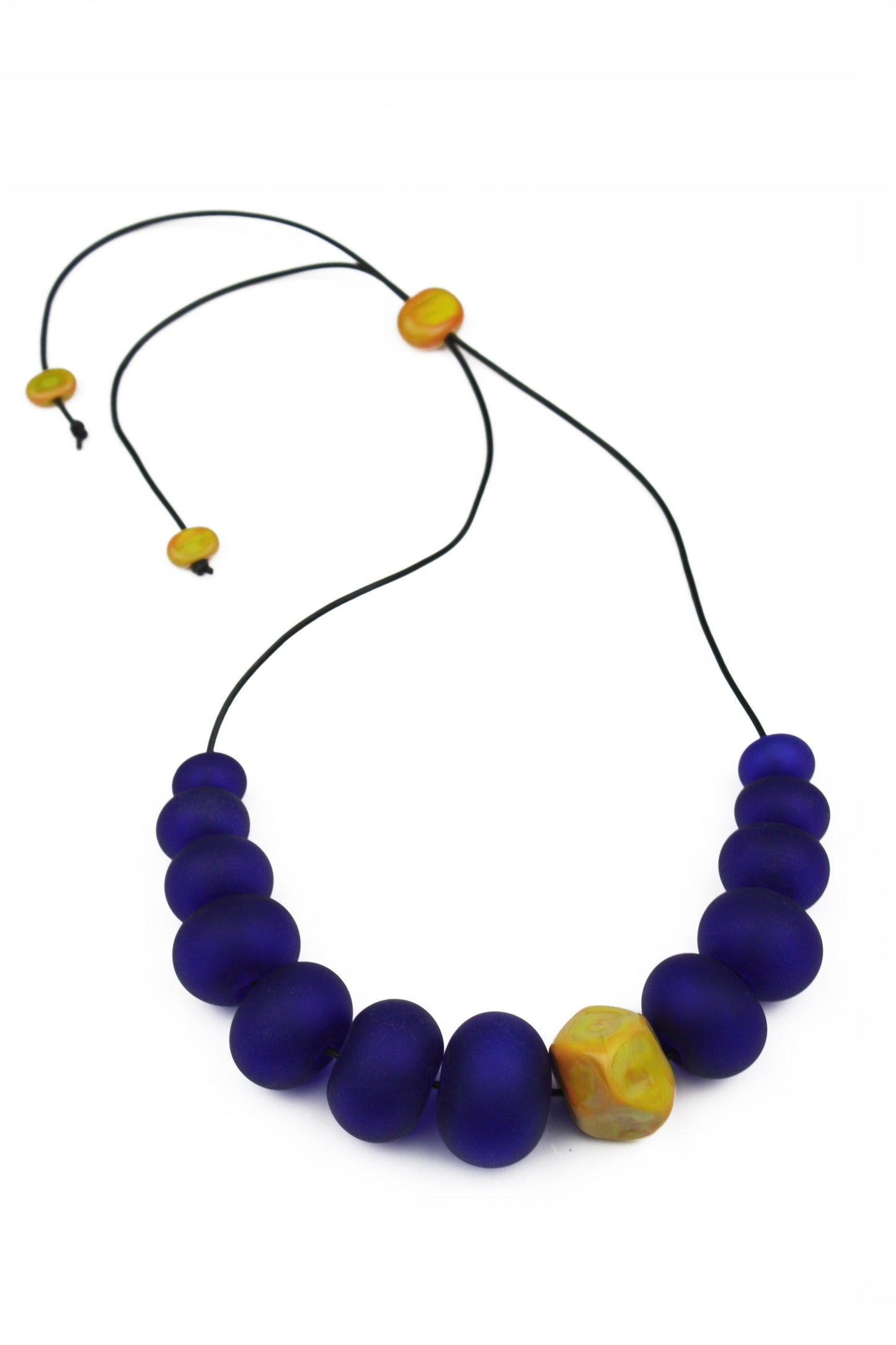 Necklace of hand blown and sandblasted hollow beads in cobalt blue glass paired with a ochre yellow glass nugget bead and strung on adjustable leather