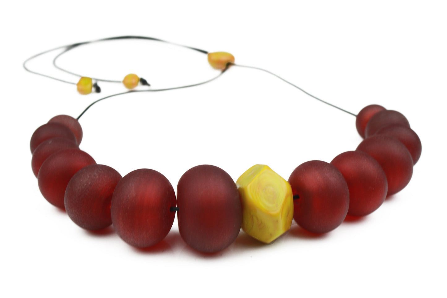 Necklace of hand blown and sandblasted hollow beads in rich deep red glass paired with a ochre yellow glass nugget bead and strung on adjustable leather