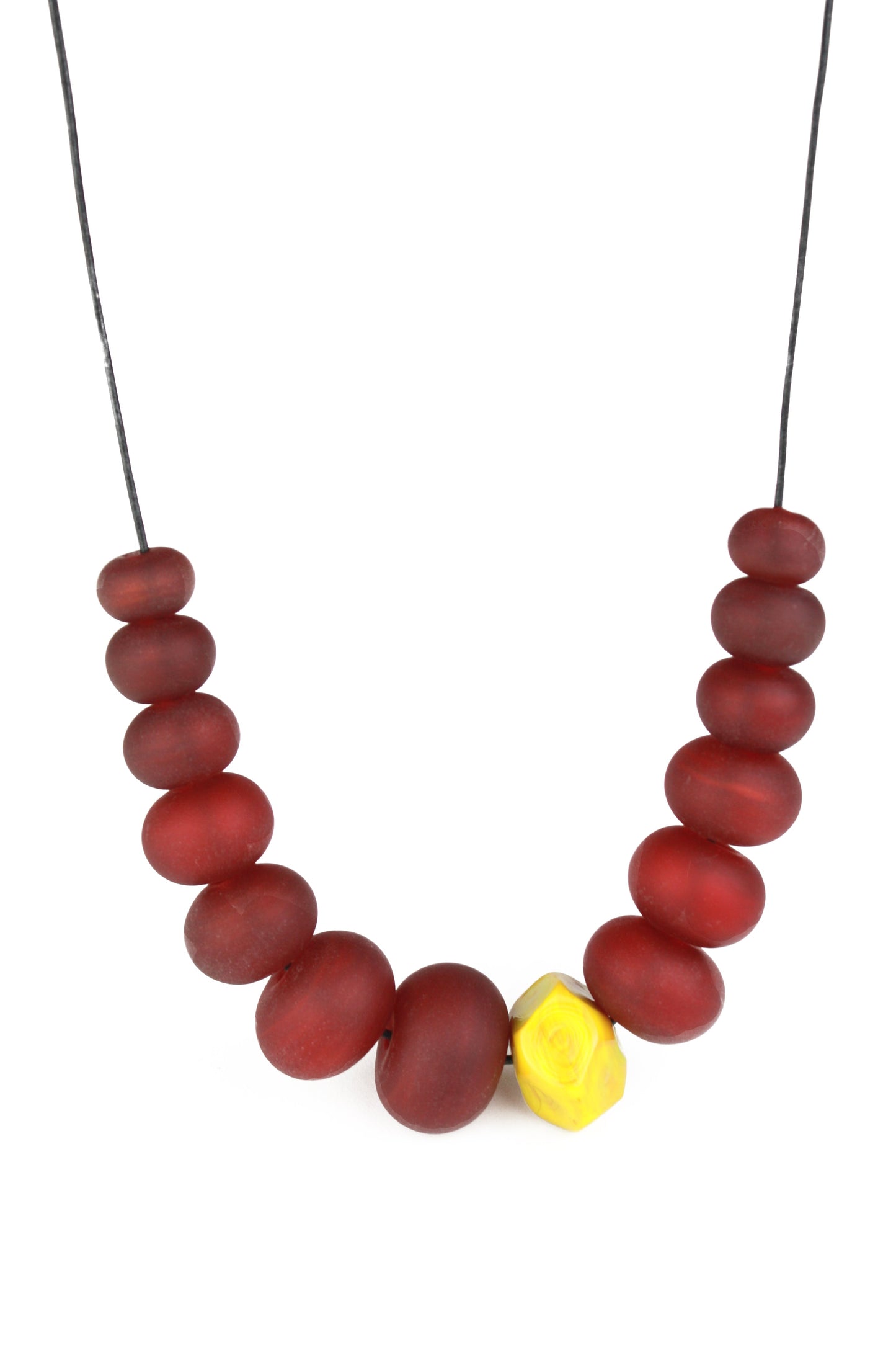 Necklace of hand blown and sandblasted hollow beads in rich deep red glass paired with a ochre yellow glass nugget bead and strung on adjustable leather
